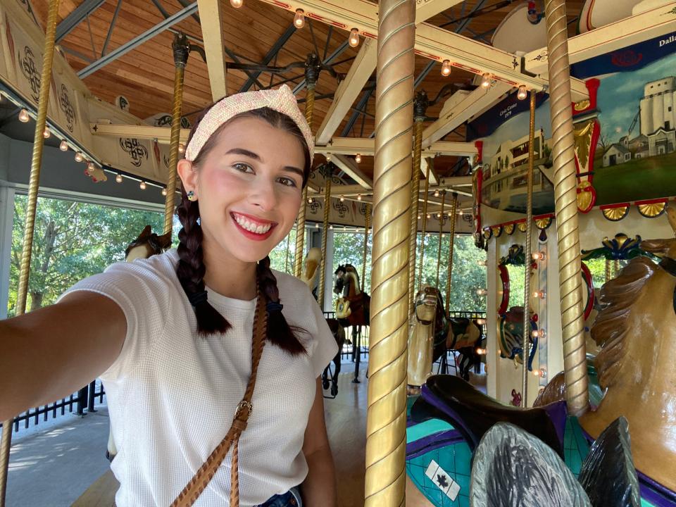 Des Moines Register reporter Paris Barraza takes a selfie at the Heritage Carousel at Union Park in Des Moines on Sept. 9, 2023.