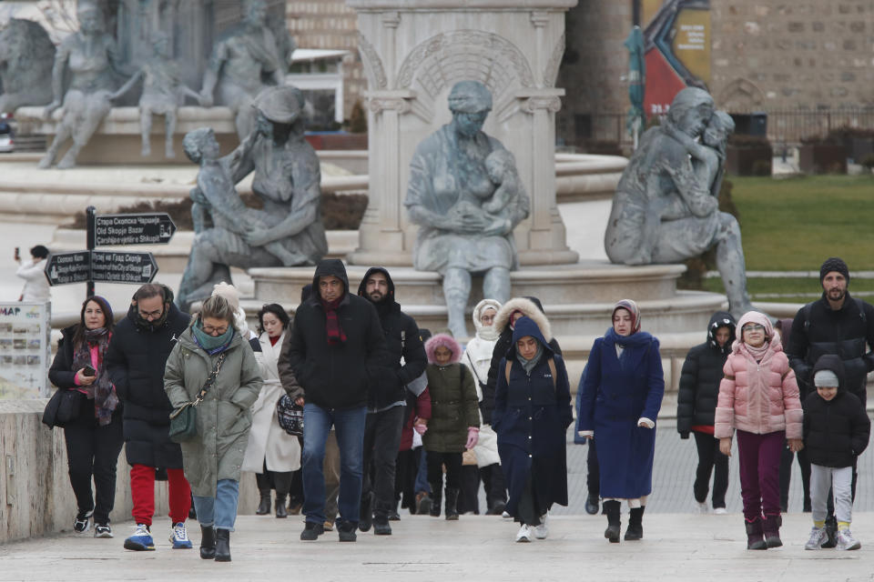 People walk through downtown Skopje, North Macedonia, on Sunday, Jan. 28, 2024. North Macedonia's parliament has approved on Sunday a new caretaker government installed ahead of general elections this May. (AP Photo/Boris Grdanoski)