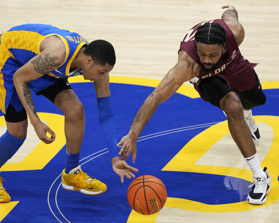 Pittsburgh guard Greg Elliott, left, and Florida State guard Darin Green Jr. scramble for a loose ball during the second half of an NCAA college basketball game in Pittsburgh, Saturday, Jan. 21, 2023. Florida State won 71-64. (AP Photo/Gene J. Puskar)