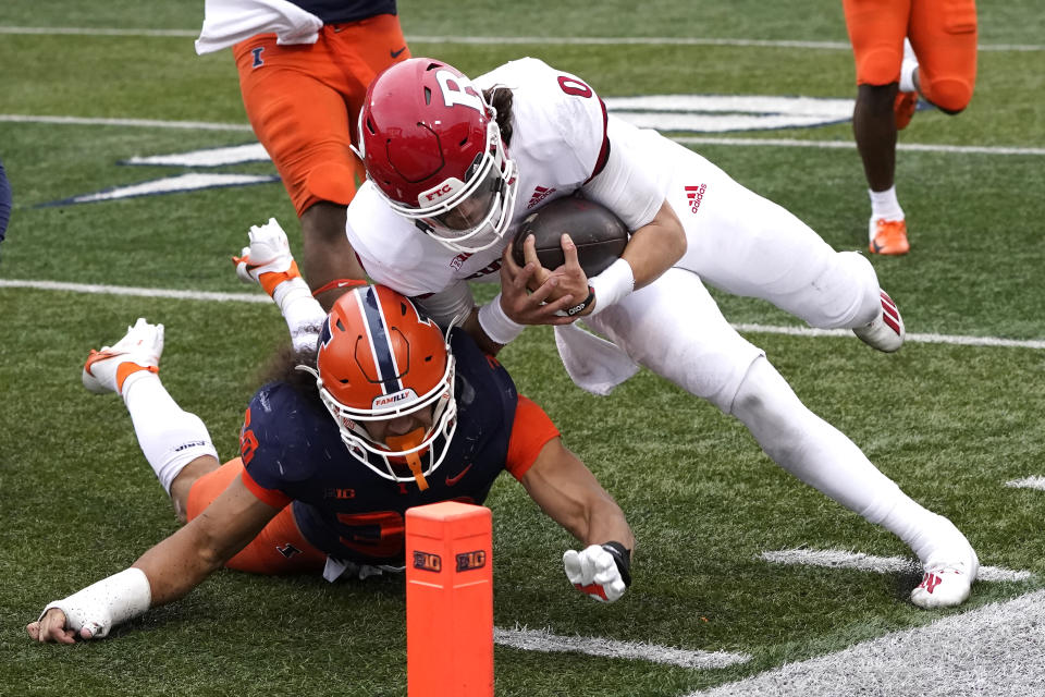 Rutgers quarterback Noah Vedral dives over Illinois defensive back Sydney Brown for a touchdown during the second half of an NCAA college football game Saturday, Oct. 30, 2021, in Champaign, Ill. Rutgers won 20-14. (AP Photo/Charles Rex Arbogast)