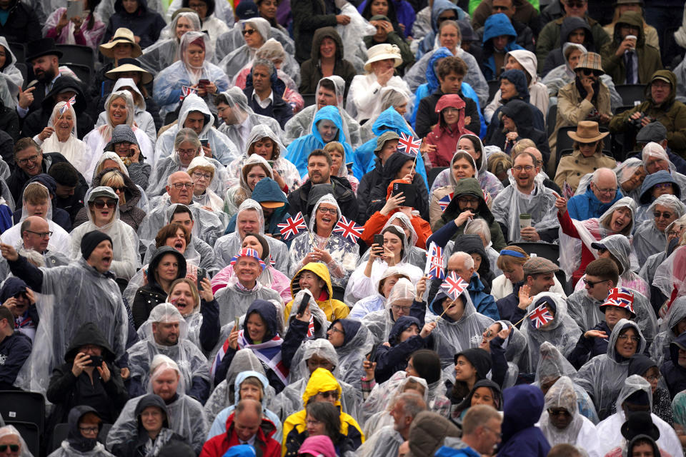 Crowds wearing rain ponchos in the grandstand opposite Buckingham Palace ahead of the coronation ceremony of King Charles III on May 6, 2023.<span class="copyright">Niall Carson—PA Wire/AP</span>