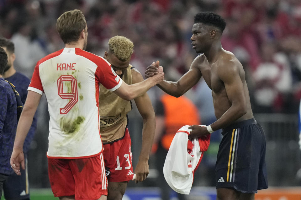 Real Madrid's Aurelien Tchouameni, right, and Bayern's Harry Kane greet each other at the end of the Champions League semifinal first leg soccer match between Bayern Munich and Real Madrid at the Allianz Arena in Munich, Germany, Tuesday, April 30, 2024. (AP Photo/Matthias Schrader)