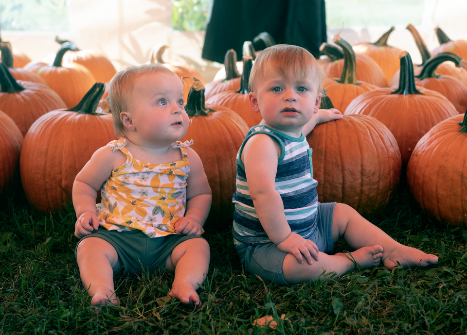 Eleven-month-old twins Ameilia and Owen Meyer of Streetsboro sit with pumpkins at Dussel Farm on Oct. 3.