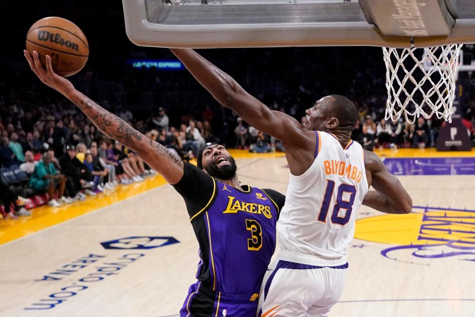 Los Angeles Lakers forward Anthony Davis, left, shoots as Phoenix Suns center Bismack Biyombo defends during the first half of an NBA basketball game Friday, April 7, 2023, in Los Angeles. (AP Photo/Mark J. Terrill)