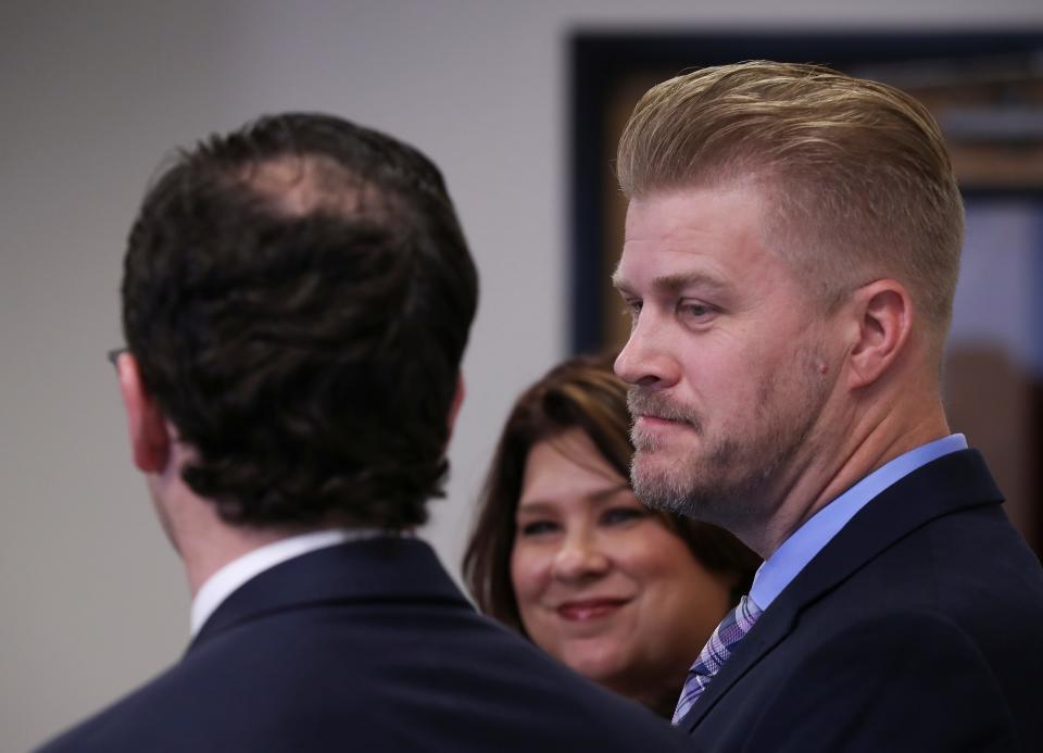 Patrick Baker, right, who was recently pardoned by former Gov. Matt Bevin, smiled at his attorneys Elliot Slosar, left, and Amy Robinson Staples during a press conference in Lexington, Ky. on Dec. 17, 2019.  Baker's pardon has been criticized because his family donated to Bevin's reelection campaign.