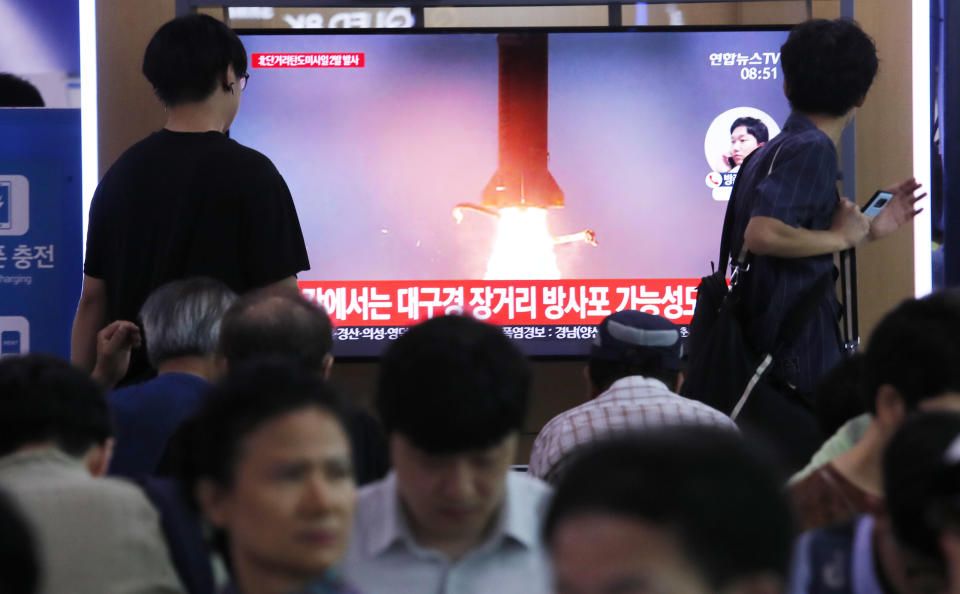 People watch a TV showing a file image of North Korea's missile launch during a news program at the Seoul Railway Station in Seoul, South Korea, Wednesday, July 31, 2019. North Korea on Wednesday fired several unidentified projectiles off its east coast, South Korea's military said, less than a week after the North launched two short-range ballistic missiles into the sea in a defiance of U.N. resolutions. The signs read: "Possibility of long-distance multiple rocket launch system." (AP Photo/Ahn Young-joon)