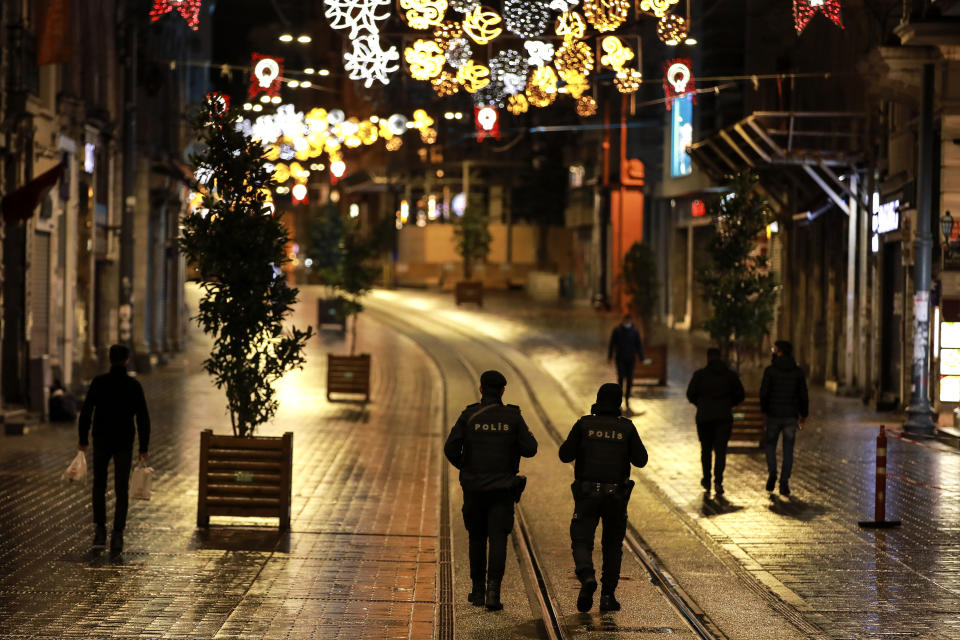 FILE - In this Saturday, Nov. 21, 2020, file photo, police officers patrol Istiklal street, the main shopping street in Istanbul, minutes into the lockdown, part of the new measures to try curb the spread of the coronavirus. When Turkey changed the way it reports daily COVID-19 infections, it confirmed what medical groups and opposition parties have long suspected — that the country is faced with an alarming surge of cases that is fast exhausting the Turkish health system. The official daily COVID-19 deaths have also steadily risen to record numbers in a reversal of fortune for the country that had been praised for managing to keep fatalities low. With the new data, the country jumped from being one of the least-affected countries in Europe to one of the worst-hit.(AP Photo/Emrah Gurel, File)