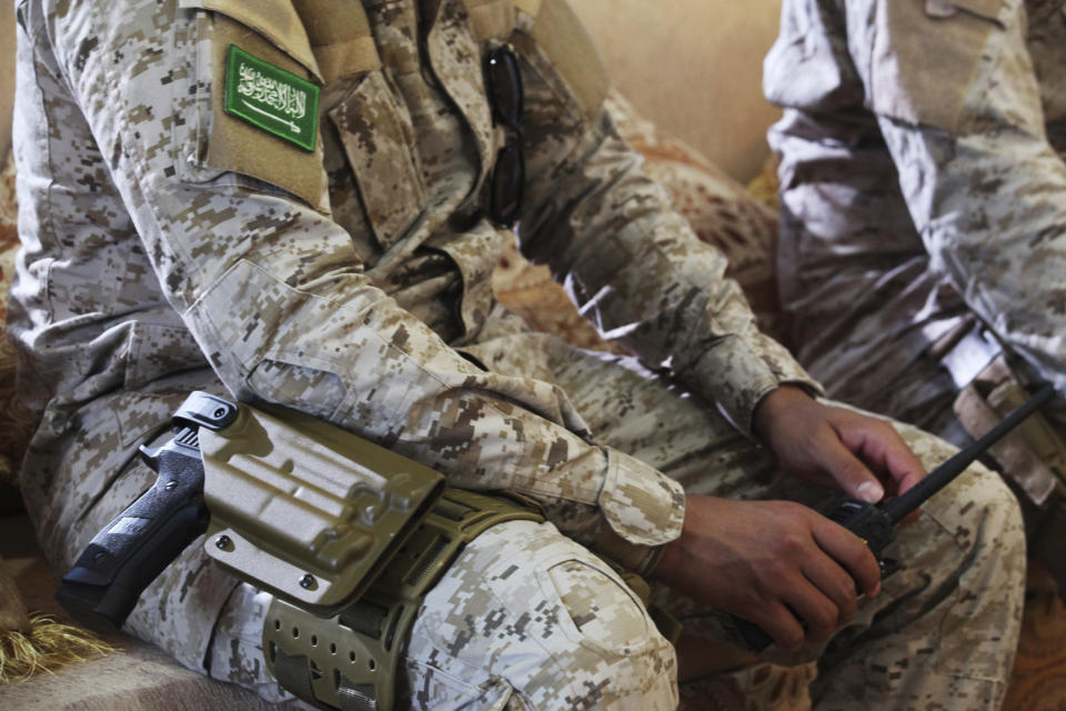 FILE - In this Nov. 28, 2018, file photo, an armed Saudi soldier holds a walkie-talkie near Mukalla, Yemen, at an airport now serving as a military base for the United Arab Emirates. (AP Photo/Jon Gambrell, File)