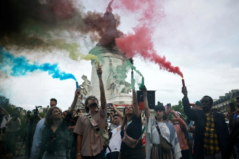 Manifestantes encienden bengalas de humo en la plaza de la República de París para protestar contra las "consecuencias sociales" de los Juegos Olímpicos, el 25 de julio de 2024 (OLYMPIA DE MAISMONT)
