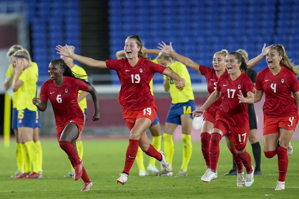 Players of Canada celebrate beating Sweden in a penalty shootout during the women's soccer match for the gold medal at the 2020 Summer Olympics, Friday, Aug. 6, 2021, in Yokohama, Japan. (AP Photo/Fernando Vergara)