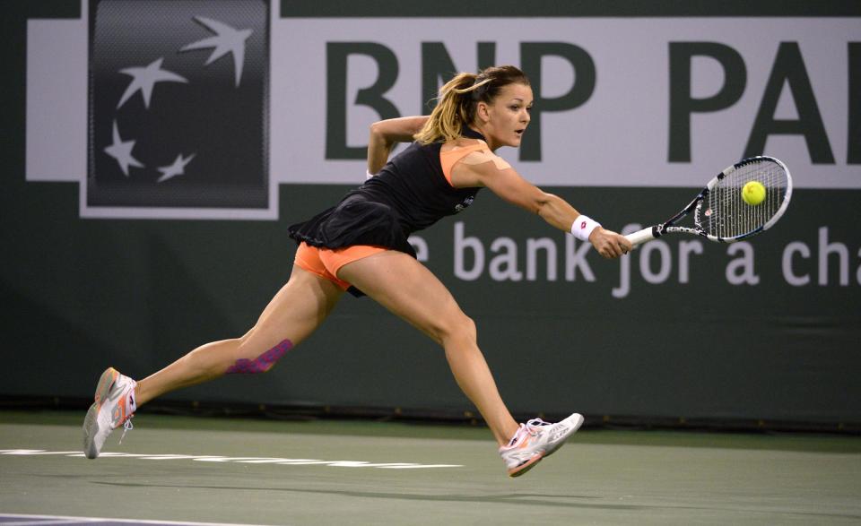 La polaca Agnieszka Radwanska contesta la pelota a la rumana Simona Halep, en su partido de semifinales del torneo en Indian Wells, en California, el viernes 14 de marzo de 2014. Radwanska ganó 6-3 y 6-4 para avanzar a la final. (AP Foto/Mark J. Terrill)