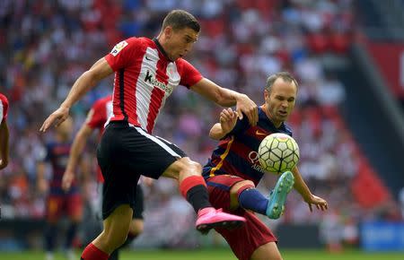 Barcelona's Andres Iniesta (R) fights for the ball with Athletic Bilbao's Oscar de Marcos during their Spanish first division soccer match at San Mames stadium in Bilbao, northern Spain, August 23, 2015. REUTERS/Vincent West