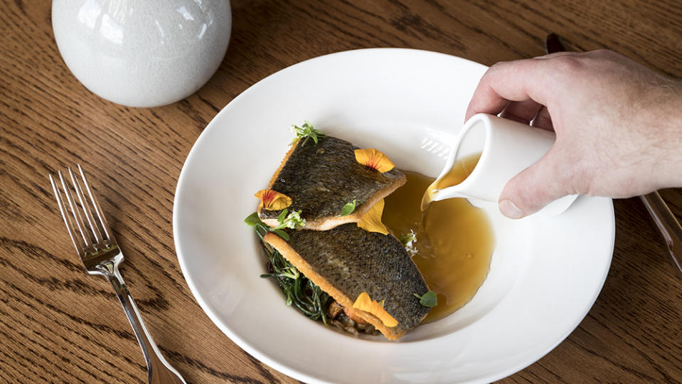 Sunburst trout with trout belly consommé, rye berries, chanterelle mushrooms and kilt greens. - Credit: Ball & Albanese