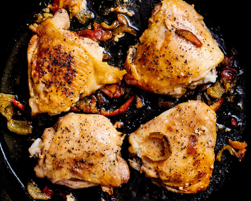 Spicy chicken thighs in skillet.