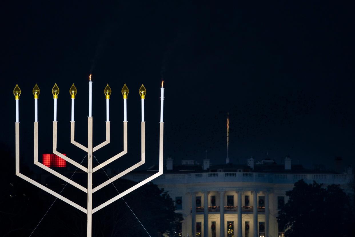 The White House is seen behind the newly lit National Menorah during a ceremony in President’s Park just south of the White House on 10 December, 2020 (Getty Images)