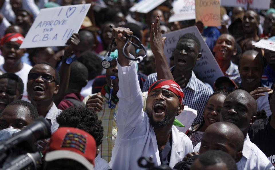 A doctor holds his stethoscope in the air as he and other medical staff protest the detention of their union leaders, outside an appeal court in Nairobi, Kenya Wednesday, Feb. 15, 2017. A Kenyan court has released seven doctors who are officials in the medics' union and who were jailed earlier this week for not calling off a strike by doctors working in public institutions. (AP Photo/Ben Curtis)