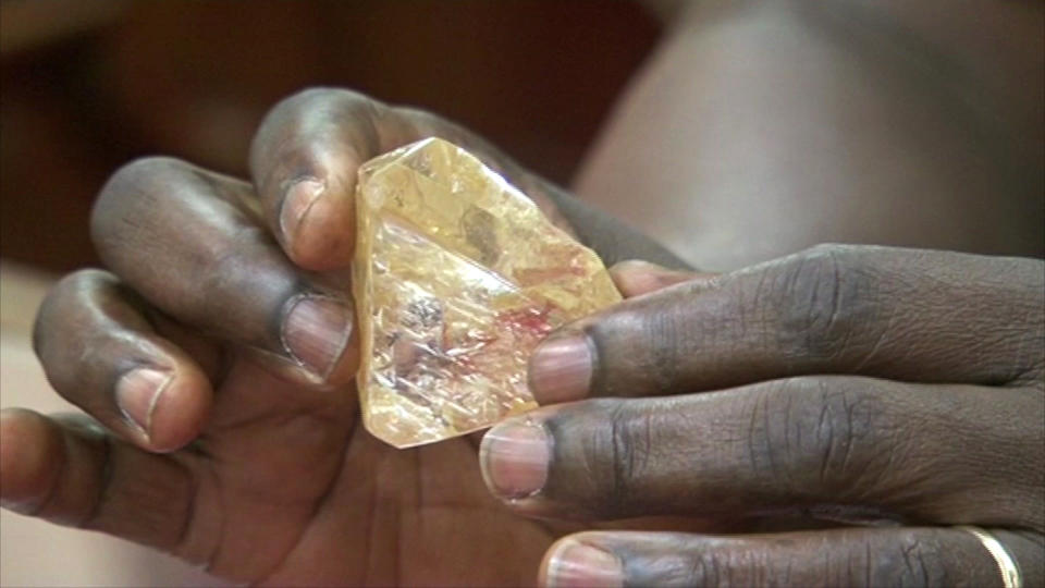 In this photo taken from video footage, Sierra Leone's President Ernest Bai Koroma hands a diamond during a meeting with delegates of Kono district, where the gem was found, at the presidential office in Freetown, Sierra Leone, Thursday, March 16, 2017. A pastor in Sierra Leone has discovered the largest uncut diamond found in more than four decades in this West African country and has turned it over to the government, saying he hopes it helps to boost recent development in his impoverished nation. (SLBC via AP)