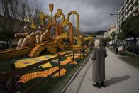 A visitor examines a sculpture made of lemons during the 90th edition of the Lemon Festival in Menton, France, Friday, March 1, 2024. (AP Photo/Daniel Cole)