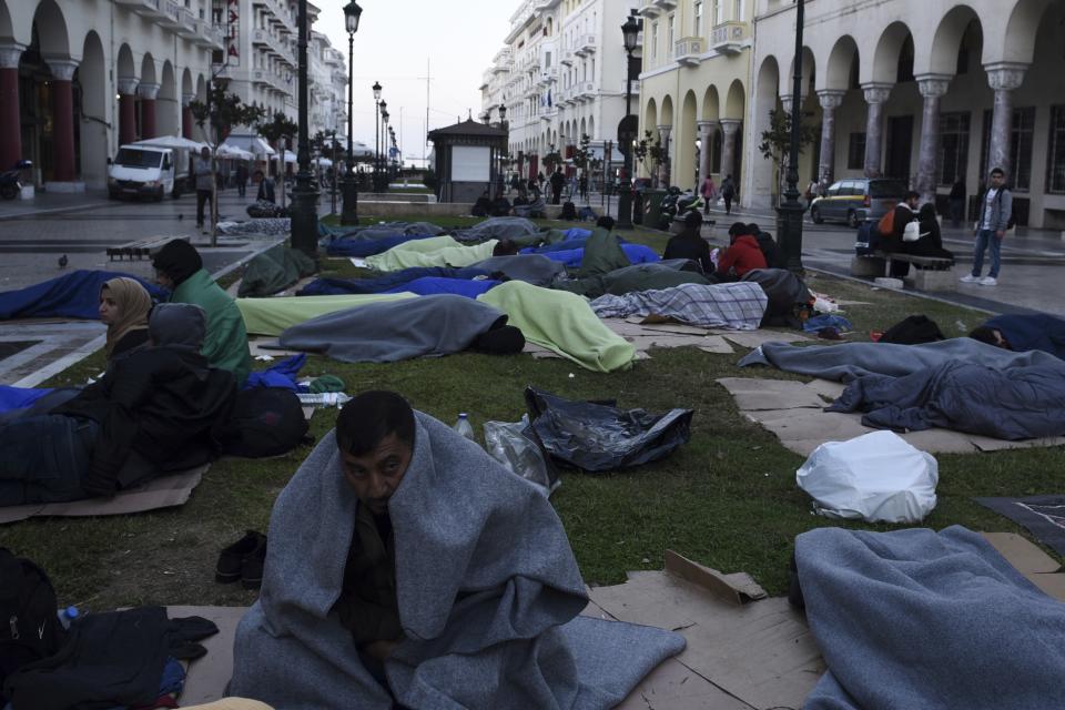 Kurdish migrants wait outside a police station in Aristotelous Square at the northern Greek city of Thessaloniki, Monday, Oct. 8, 2018. Dozens of refugees and migrants have gathered outside a police station in Greece's second largest city, waiting for hours to be formally arrested and gain temporary residence in the European Union country. (AP Photo/Giannis Papanikos)