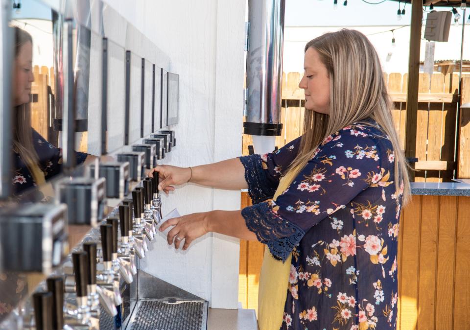 Pickerington resident Kaitlin Crist uses the self-pour beverage wall at Cardo's Pizza & Tavern on June 27.