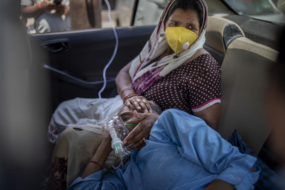 FILE - In this Saturday, April 24, 2021 file photo, a patient breathes with the help of oxygen provided by a gurdwara, a Sikh place of worship, inside a car in New Delhi, India. India's medical oxygen shortage has become so dire that a gurdwara began offering free breathing sessions with shared tanks to COVID-19 patients waiting for a hospital bed. (AP Photo/Altaf Qadri)