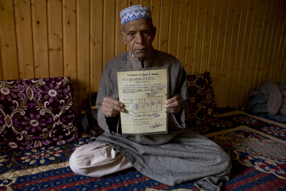 Ghulam Mohammad Zargar, an elderly Kashmiri man shows his domicile document locally know as "State Subject" which was only held by permanent residents of Jammu and Kashmir in Srinagar, Indian controlled Kashmir, Thursday, Oct. 31, 2019. Zargar said, with the abrogation of article 370 this document is gone and with it Kashmiri identity has also gone. India on Thursday formally implemented legislation approved by Parliament in early August that removes Indian-controlled Kashmir's semi-autonomous status and begins direct federal rule of the disputed area amid a harsh security lockdown and widespread public disenchantment. (AP Photo/ Dar Yasin)