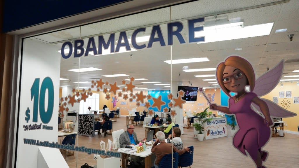 An insurance agent talks with clients inside the main location of Las Madrinas de los Seguros, which is Spanish for “The Godmothers of Insurance,” at a shopping center in Miami last month. The Biden administration says 20 million people have enrolled for health insurance through the Affordable Care Act marketplaces. (Photo: Rebecca Blackwell/AP, File)