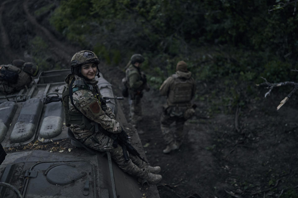 A Ukrainian soldier smiles atop an APC on the frontline in the Luhansk region, Ukraine, Sunday, May 21, 2023. (AP Photo/Libkos)