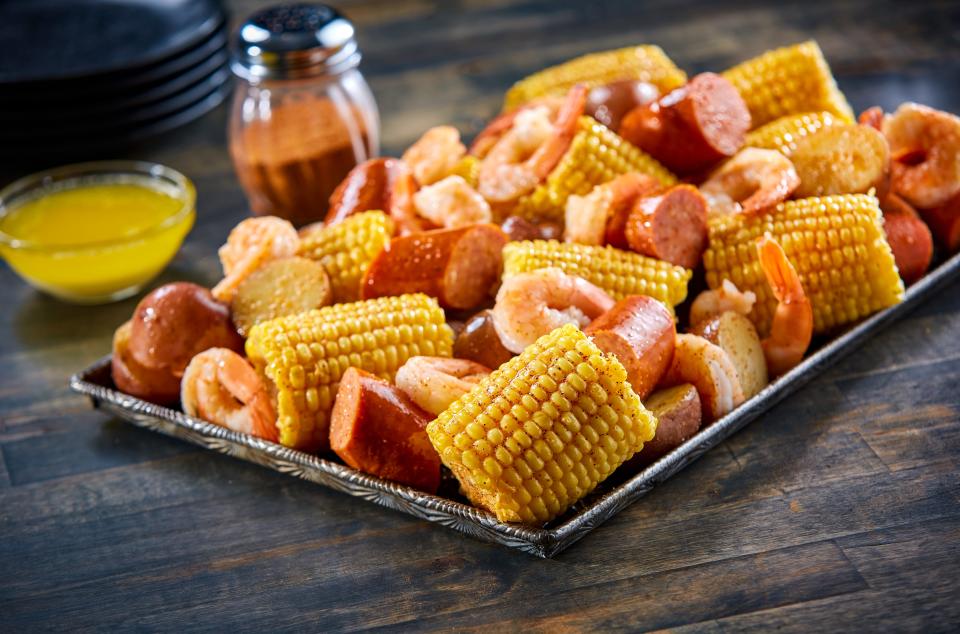 Corn on the cob, sausage and shrimp plate.