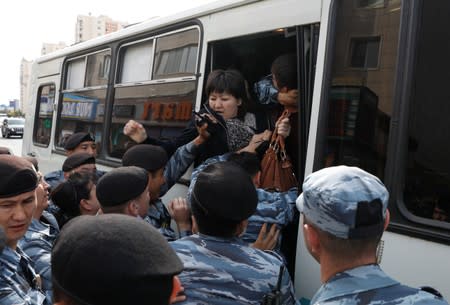 Kazakh law enforcement officers detain a woman during a rally held by opposition supporters in Nur-Sultan