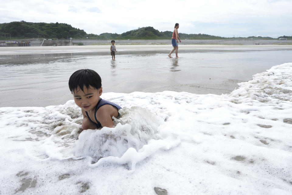 Family members enjoy at the Usuiso beach in Iwaki, northeastern Japan, Thursday, July 6, 2023. (AP Photo/Hiro Komae)