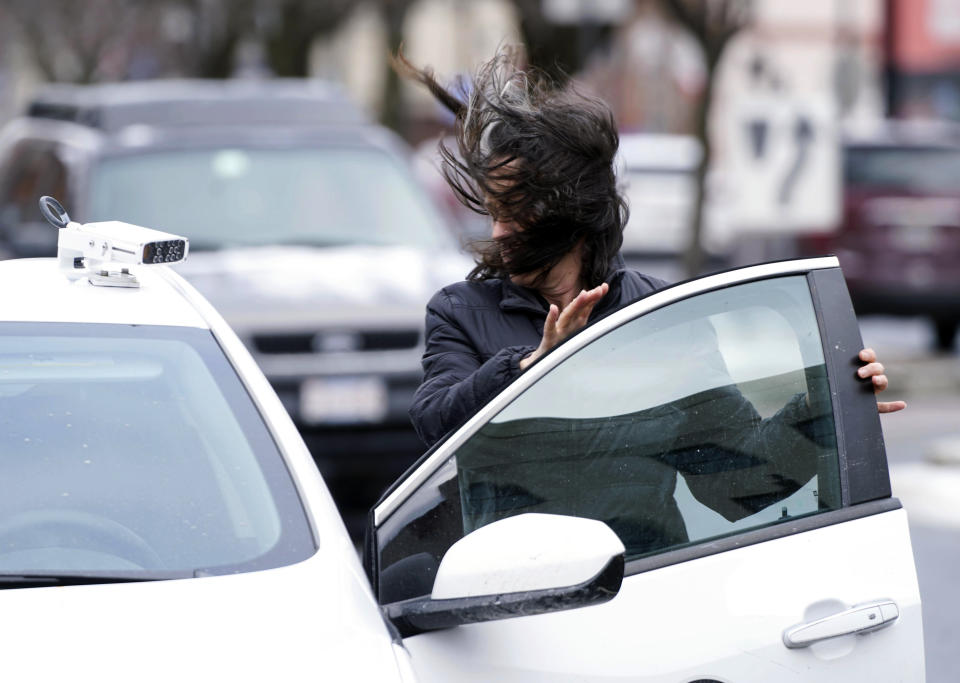 Parking enforcement officer Sally Carnevale struggles with a gust of wind as she checks out cars on North Street in Pittsfield, Mass., Monday, February 25, 2019. Winds over 30 miles per hour with gusts even higher are causing poor visibility and local power outages. (Ben Garver/The Berkshire Eagle via AP)