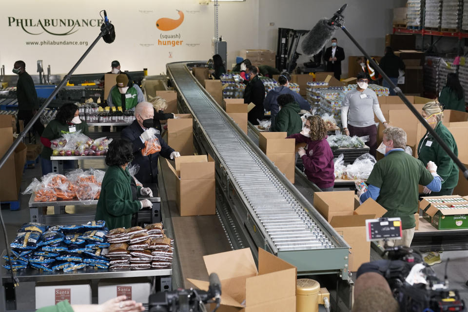 President Joe Biden and first lady Jill Biden pack produce while they volunteer at hunger relief organization Philabundance, Sunday, Jan. 16, 2022, in Philadelphia. (AP Photo/Patrick Semansky)