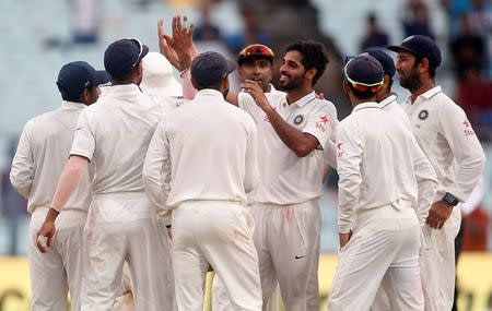Cricket - India v New Zealand - Second Test cricket match - Eden Gardens, Kolkata, India - 01/10/2016. India's Bhuvneshwar Kumar celebrates with teammates after taking the wicket of New Zealands' Matt Henry. REUTERS/Rupak De Chowdhuri