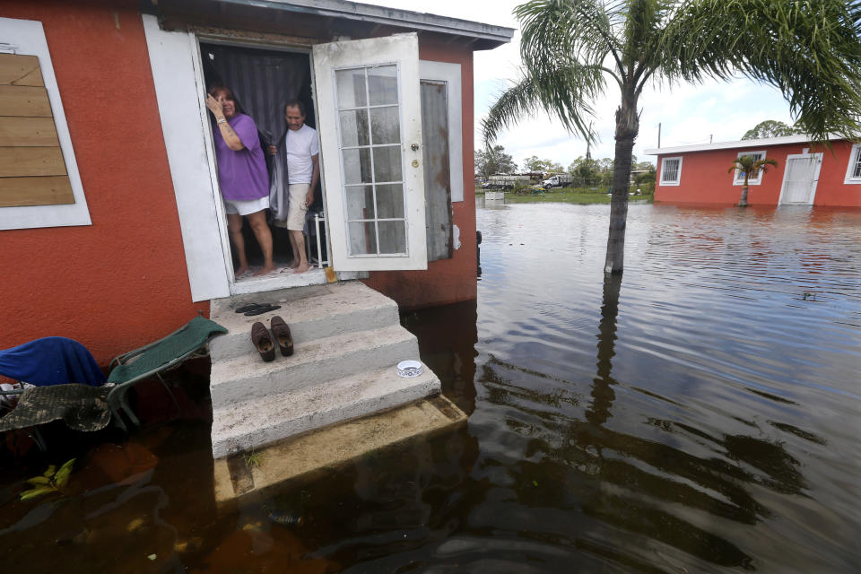 <p>Quintana and Liz Perez look out at the flooding outside their home in the aftermath of Hurricane Irma in Immokalee, Fla., Sept. 11, 2017. (Photo: Gerald Herbert/AP) </p>