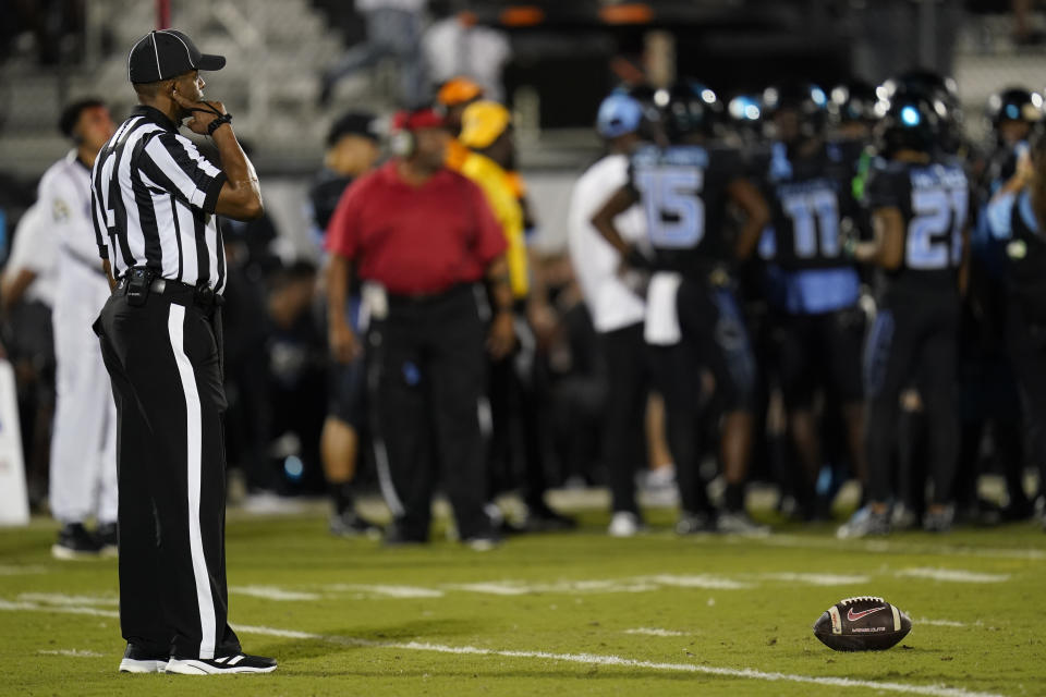 An official waits next to the ball during a time out in the first half of an NCAA college football game between Central Florida and Temple, Thursday, Oct. 13, 2022, in Orlando, Fla. (AP Photo/John Raoux)