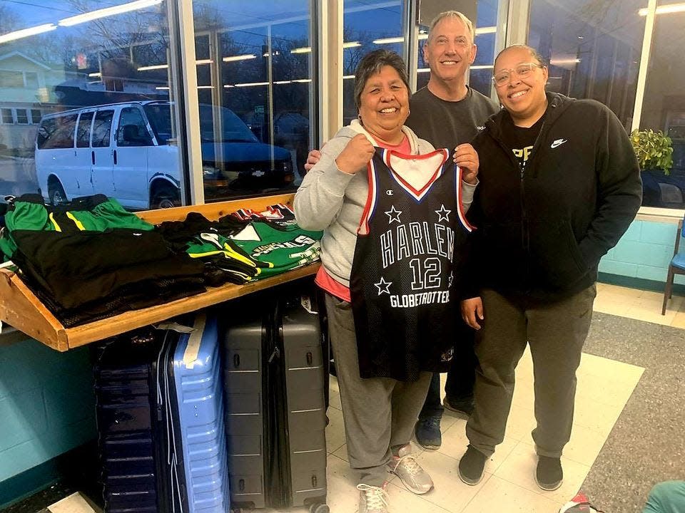 Topeka City Councilwoman Sylvia Ortiz, Oakland Easy Wash owner Eric Naill and Ortiz's daughter, Tania Gibbs, from left, posed with a Harlem Globetrotters jersey Sunday at Naill's business.