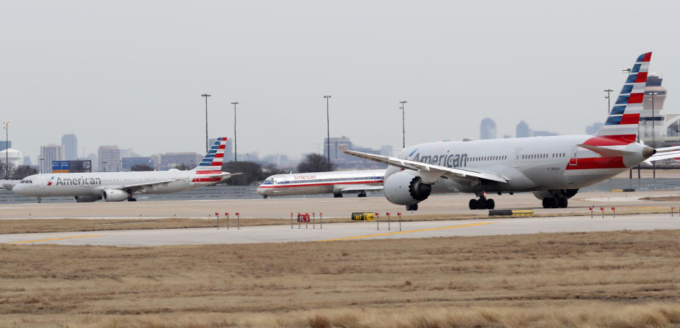 Jets line up on the tarmac at Dallas/Fort Worth International Airport in Grapevine, Dallas, Wednesday, Feb. 13, 2019. Flights at Dallas' two major airports were temporarily halted after air traffic controllers were forced to evacuate a building because of smoke, and the resulting flight delays are expected to continue for hours. (AP Photo/LM Otero)