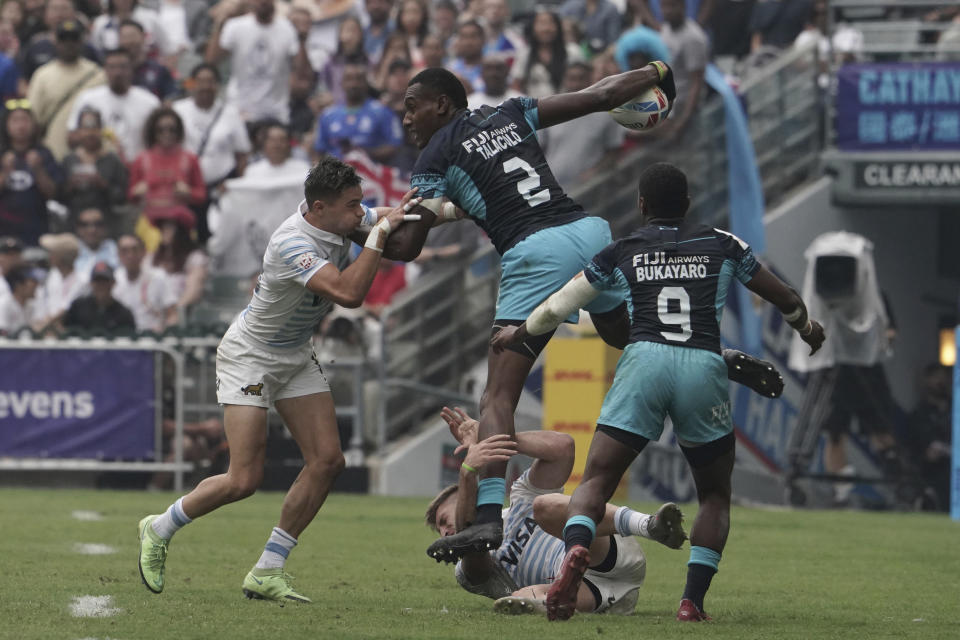 Fiji's Joseva Talacolo jumps over Argentina's Matias Osadczuk as he tries to break away during the second day of the Hong Kong Sevens rugby tournament in Hong Kong, Saturday, April 1, 2023. (AP Photo/Anthony Kwan)