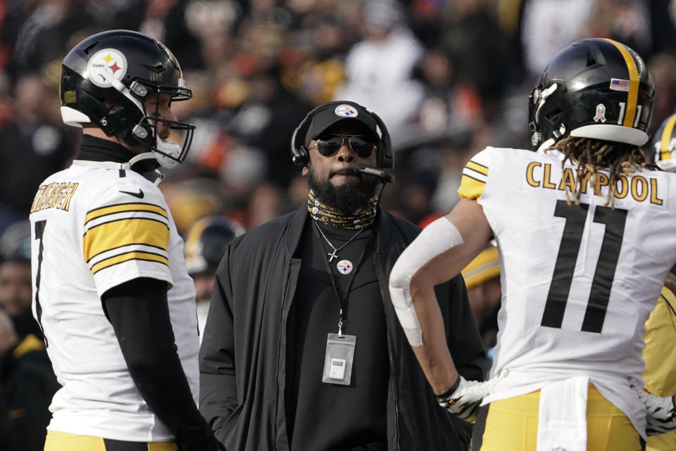 Pittsburgh Steelers head coach Mike Tomlin, center, looks up at the videoboard as he stands with quarterback Ben Roethlisberger (7) and wide receiver Chase Claypool (11) during a timeout during the second half of an NFL football game against the Cincinnati Bengals, Sunday, Nov. 28, 2021, in Cincinnati. (AP Photo/Aaron Doster)