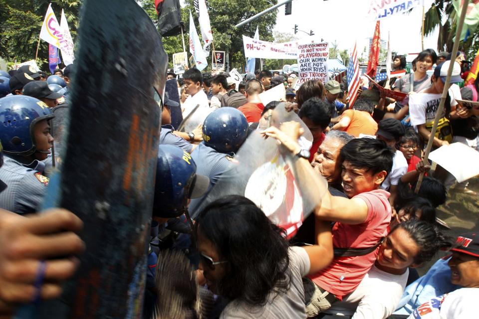 Protesters scuffle with anti-riot policeman during a protest against the upcoming visit of U.S. President Barack Obama next week, in front of the U.S. embassy in Manila April 23, 2014.