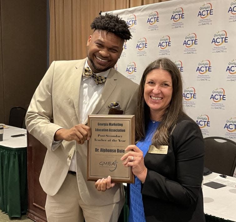 Alphonso Buie, left, accepts his award from Joni Cochran a program specialist with the Georgia Department of Education at a statewide conference held recently in Athens.
