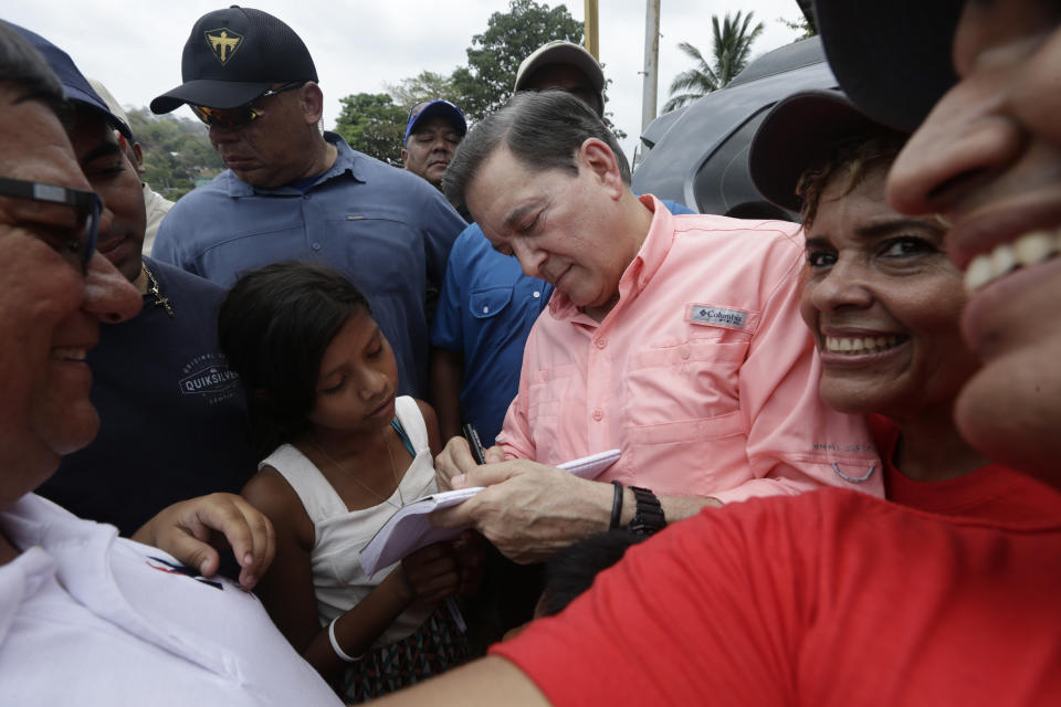 In this April 14, 2019 photo, leading presidential candidate Laurentino Cortizo, of the Democratic Revolutionary Party, signs autographs after a campaign rally in Veracruz, Panama. A recent poll by La Prensa newspaper gave Cortizo, a 66-year-old businessman with a degree in business administration from Norwich University in Vermont, a double-digit edge over his two nearest rivals. (AP Photo/Arnulfo Franco)