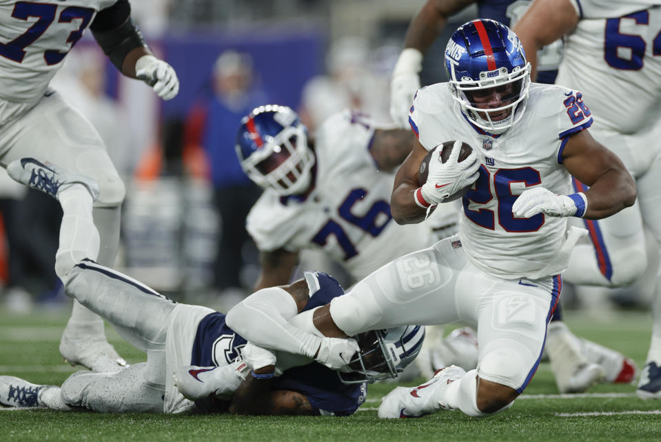 New York Giants running back Saquon Barkley (26) is tackled by Dallas Cowboys cornerback Anthony Brown (3) during the second quarter of an NFL football game, Monday, Sept. 26, 2022, in East Rutherford, N.J. (AP Photo/Adam Hunger)