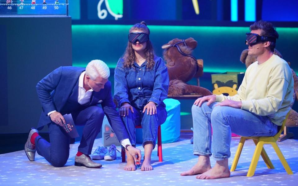 Moritz und Katharina Hellbusch aus Aurich erkennen Spielzeugfiguren mit den Füßen. Moderator Guido Cantz ist ihnen zu Diensten. (Bild: RTL / Stefan Gregorowius)