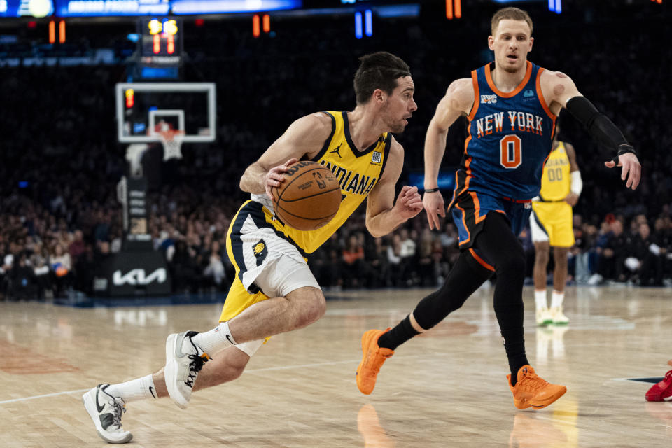 New York Knicks guard Donte DiVincenzo (0) defends as Indiana Pacers guard T.J. McConnell drives to the basket during the first half of an NBA basketball game in New York, Saturday, Feb. 10, 2024. (AP Photo/Peter K. Afriyie)