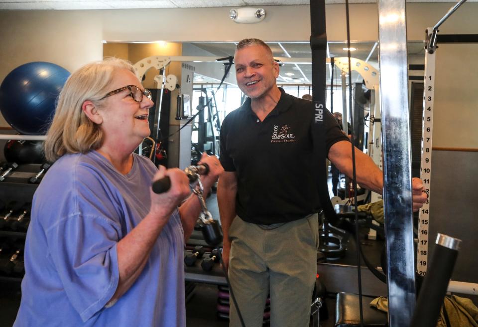 Bruce Miller, owner of Body & Soul, works with Barbara Davies during her workout.