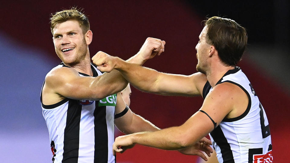 Seen here, Collingwood players substitute high-fives with forearm bumps.