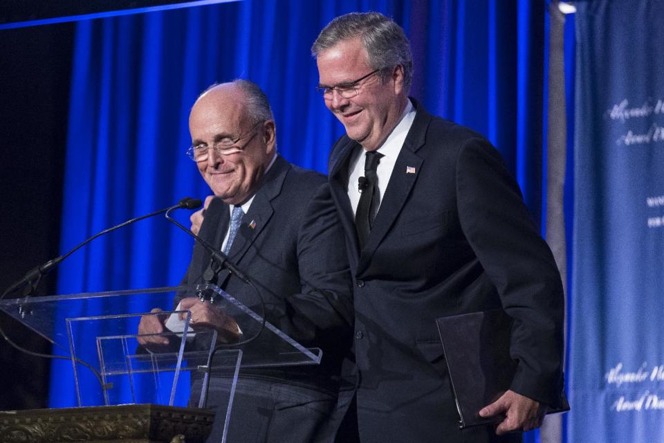 Former Florida Gov. Jeb Bush, right, hugs former New York City Mayor Rudy Giuliani at the podium after being introduced at the Manhattan Institute for Policy Research Alexander Hamilton Award Dinner, Monday, May 12, 2014, in New York. Bush and Rep. Paul Ryan, R-Wis., courted some of Wall Street’s most powerful political donors Monday night, competing for attention from tuxedoed hedge fund executives gathered in midtown Manhattan as the early jockeying in the 2016 presidential contest quietly continues. (AP Photo/John Minchillo)