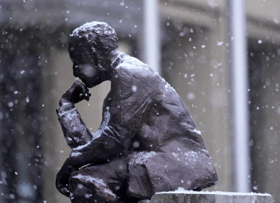 Snow collects on a statue outside the BMO Harris Banks on North Water Street as the first snow falls across the area on Halloween in Milwaukee on Tuesday, Oct. 31, 2023.